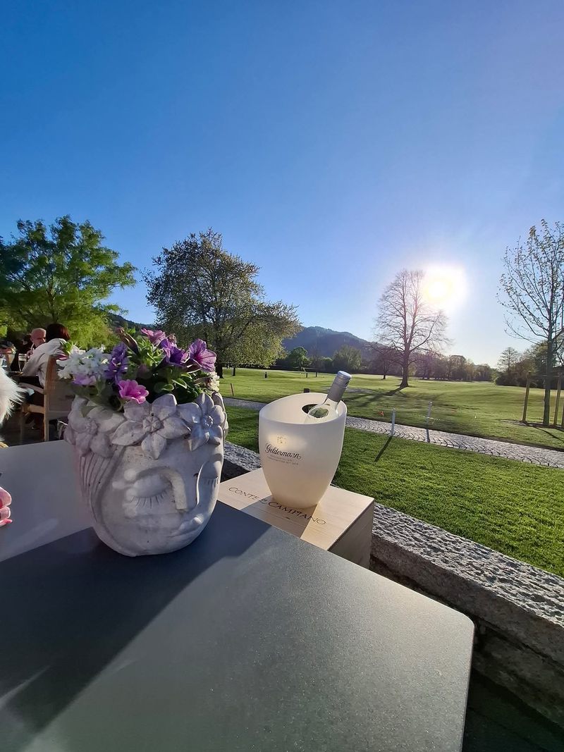 Gedeckter Tisch auf der Terrasse mit Blick auf den Golfplatz